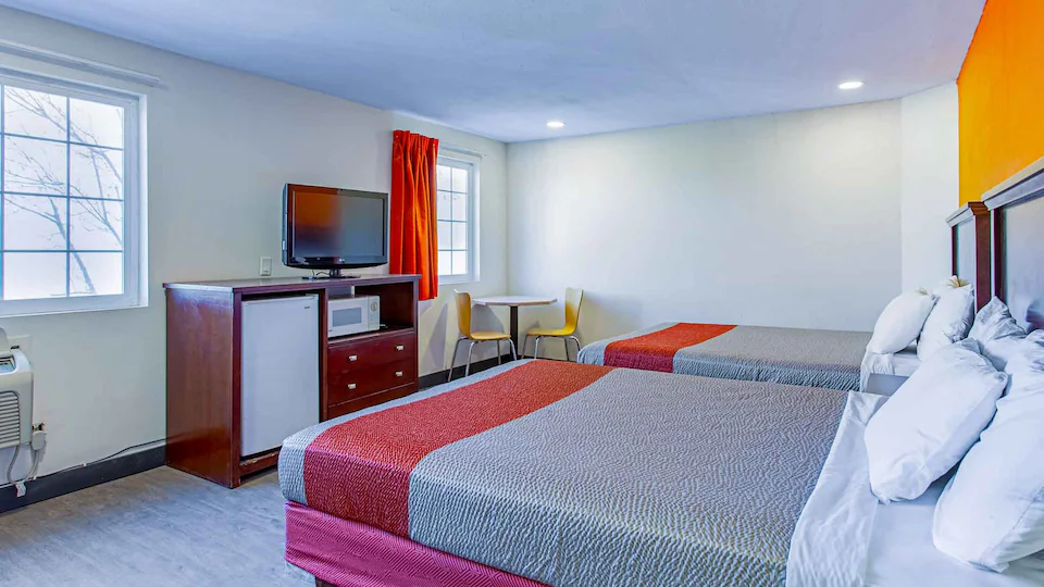 Two queen beds with microwave, refrigerator, and seating area